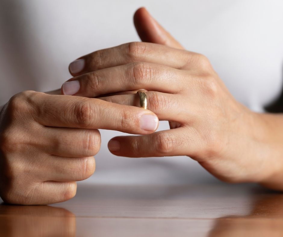 Person removing their wedding ring to symbolise no fault divorce